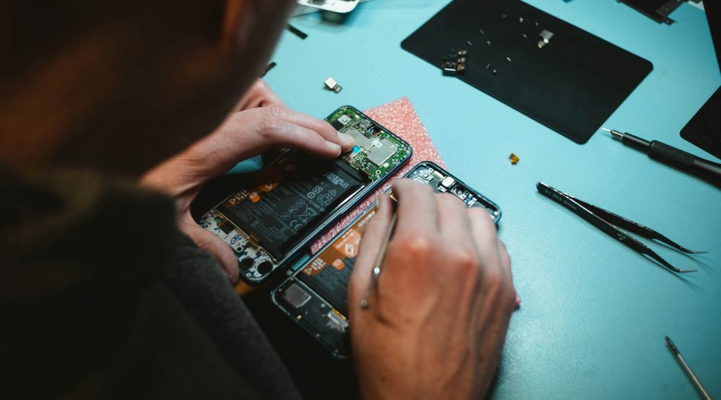 person repairing smartphones under a lighted table